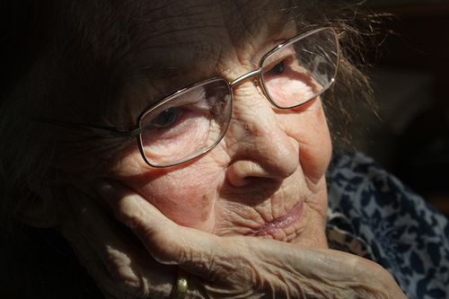 A close up of an old woman wearing glasses