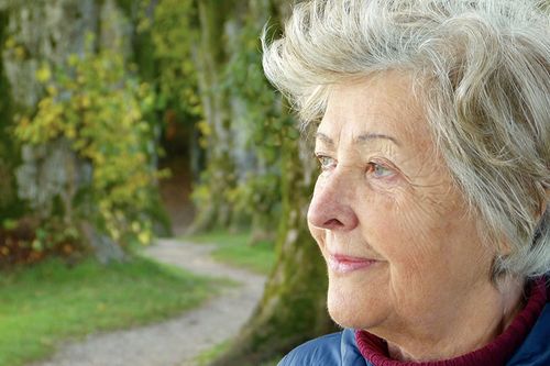 A woman with white hair looking off to the side.