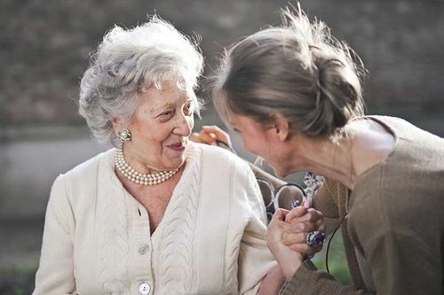 Two women are laughing together outside.