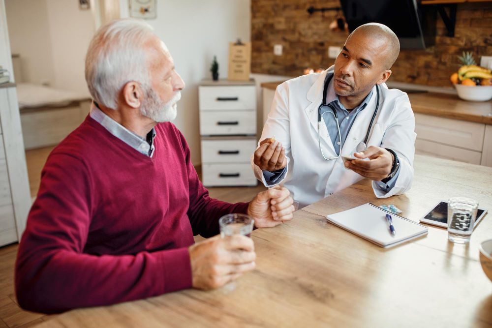 A doctor and an older man sitting at a table.