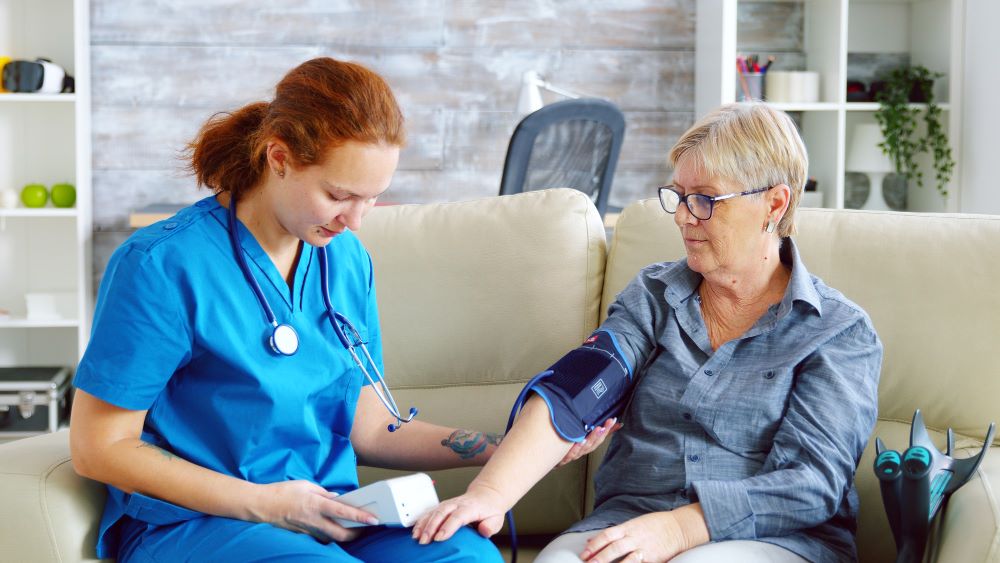 A nurse is checking the blood pressure of an older woman.