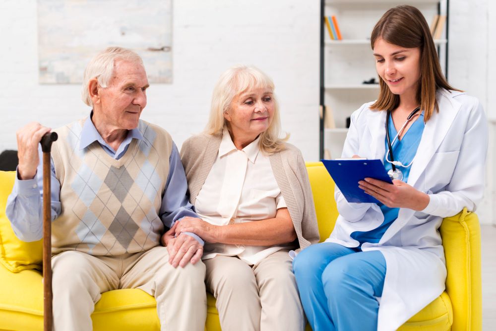 A doctor and nurse talking to an older couple.