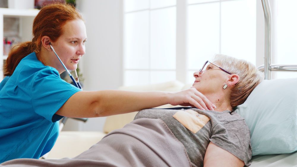 A woman is helping an older person with her neck.