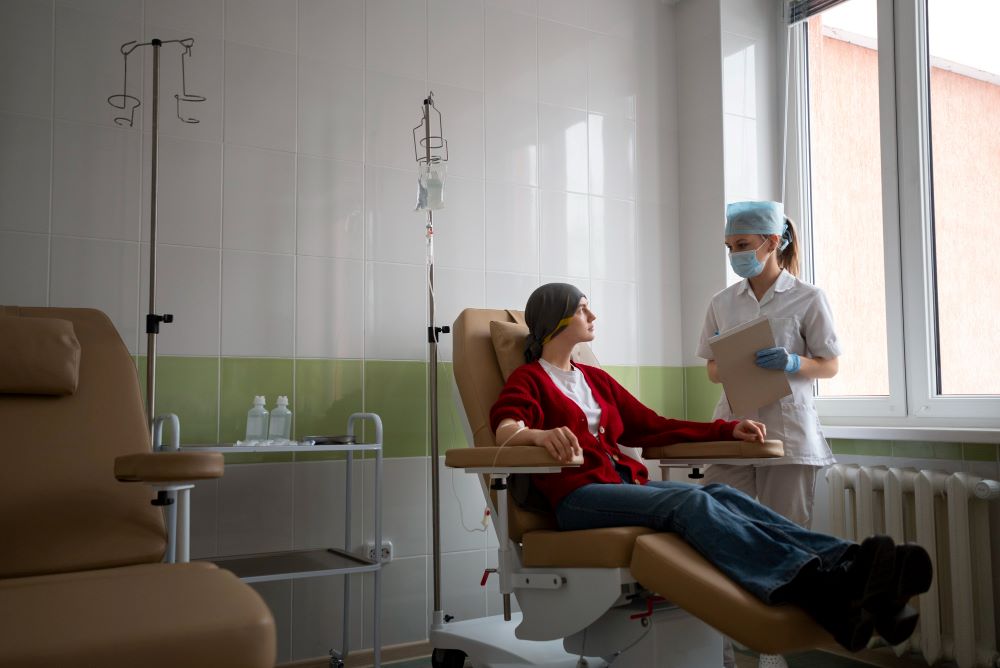 A woman sitting in a chair with another person standing next to her.