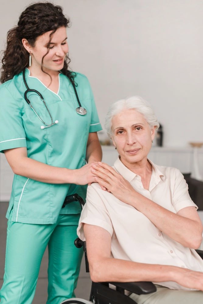 A nurse and an older woman are standing together.